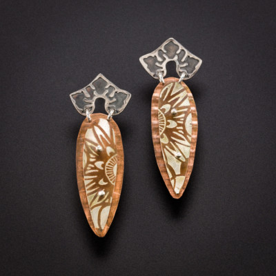 pair of earrings by Julie Packer on a dark background
