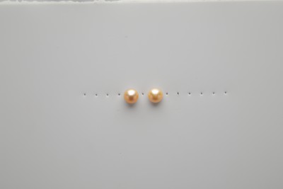 2 pearl stud earrings on Dura-Lar with row of pin holes