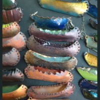 tiny metal canoes enameled and sewn by metalsmith artist and educator Angela Gleason
