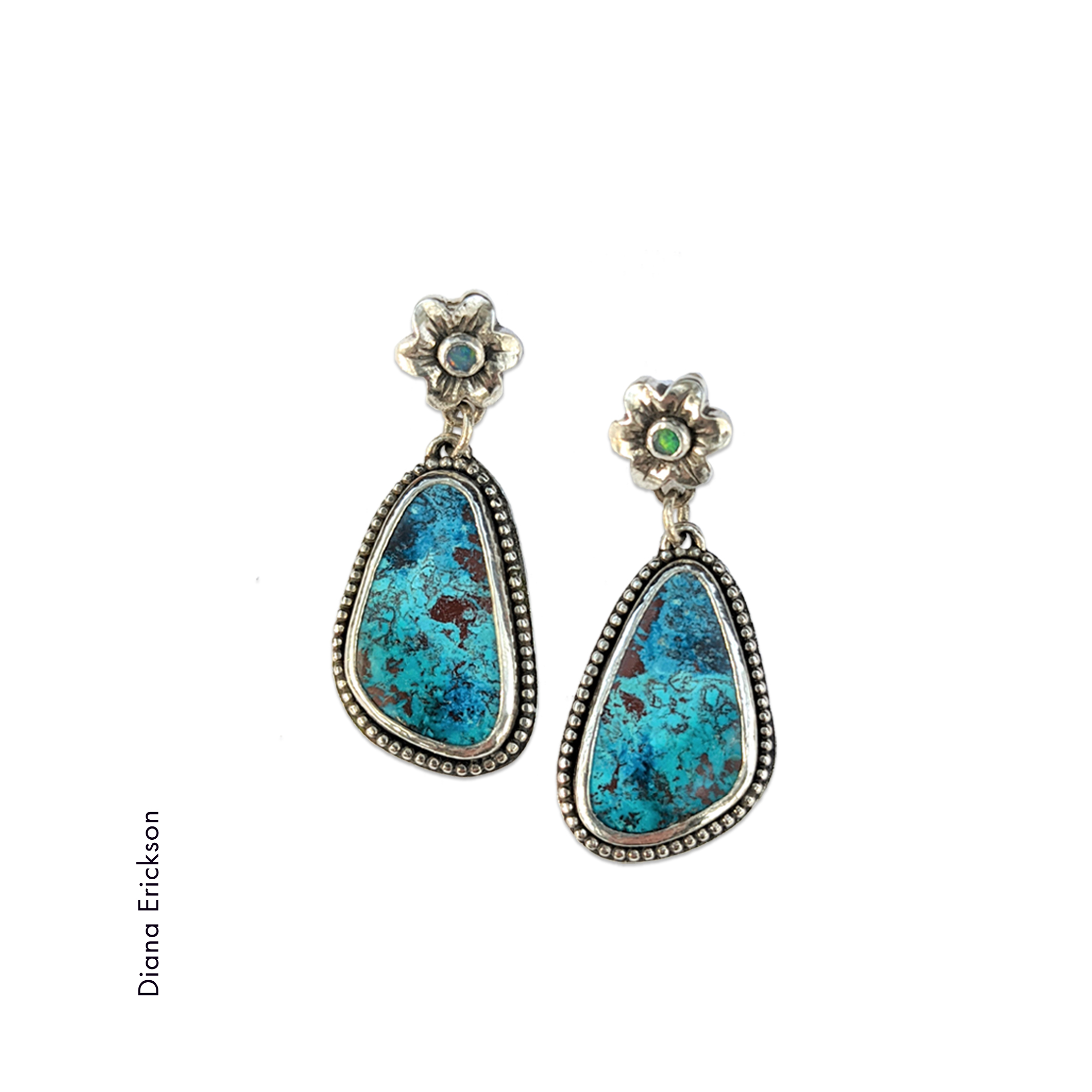 A pair of earrings with triangular deep blue turquoise stone with beaded sterling silver bezel and a silver flower by Diana Erickson
