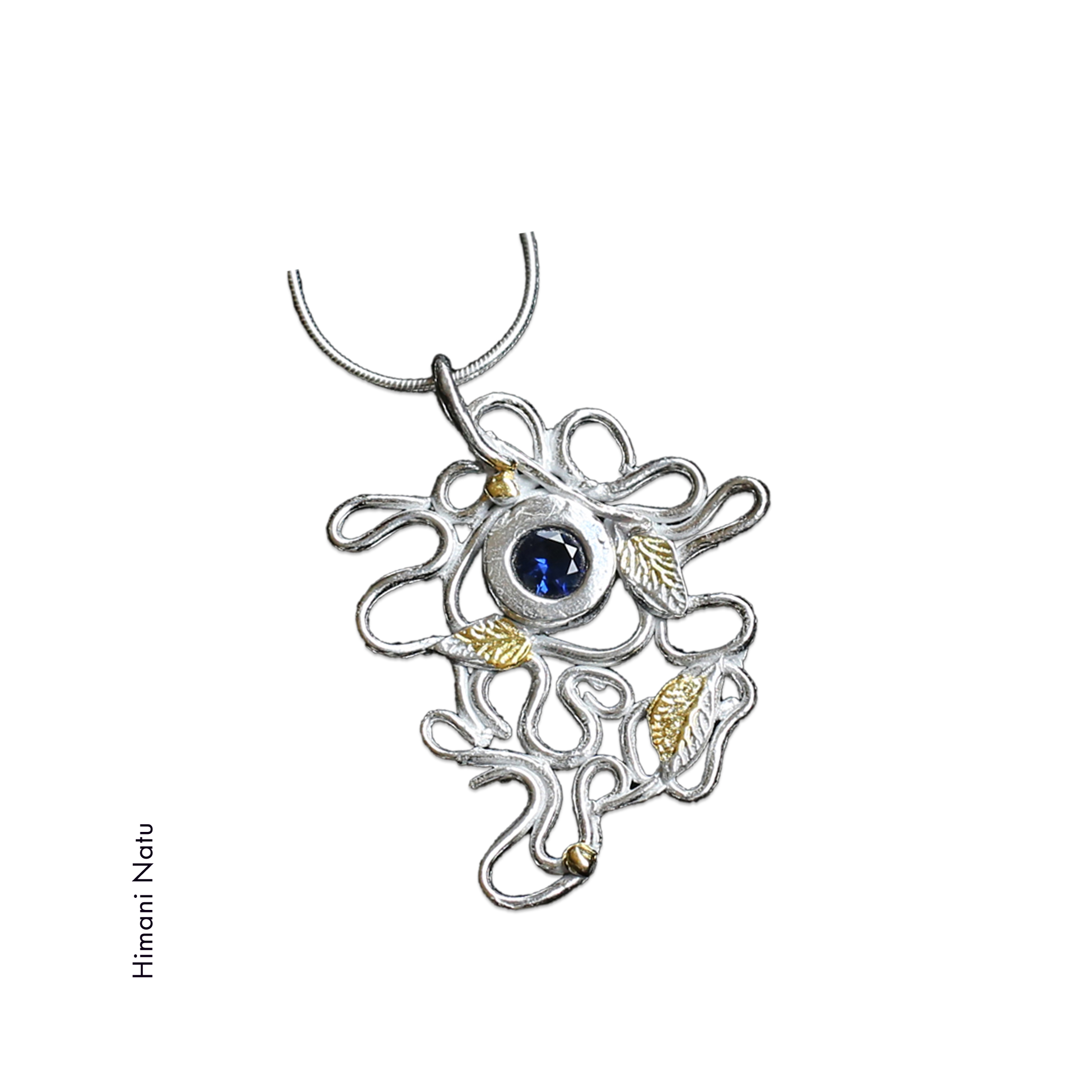 necklace with blue stone in the center, 3 formed leaves with gold accents and squiggles of silver by Himani Natu